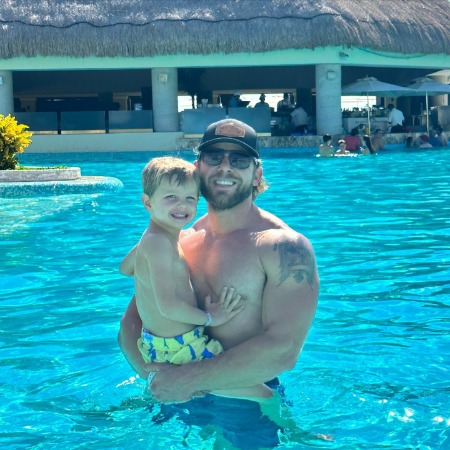 Max Thieriot shirtless in a pool with his son.